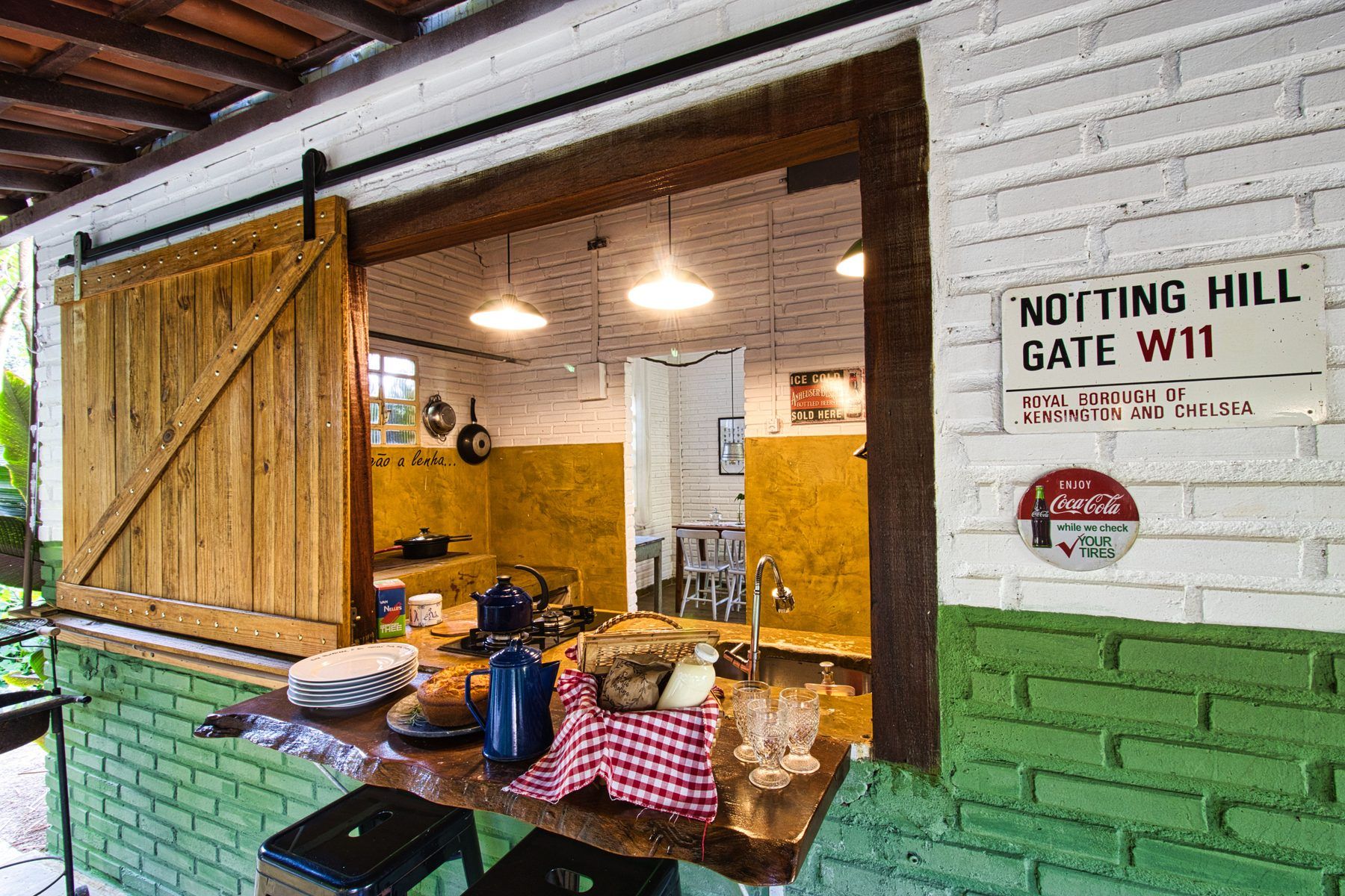 A cozinha da Casinha do Solar vista da varanda, pela janela de passagem, com a mesa posta